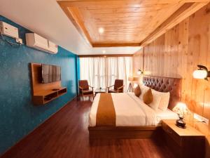 a hotel room with a bed and a desk and a television at Vista Resort, Manali - centrally Heated & Air cooled luxury rooms in Manāli
