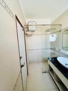 a bathroom with a sink and a glass shower door at Weekend Vibes in Kasauli