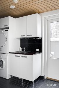 - une cuisine avec des placards blancs et un lave-linge/sèche-linge dans l'établissement Cozy Holiday Home with Outside Jacuzzi, à Espoo