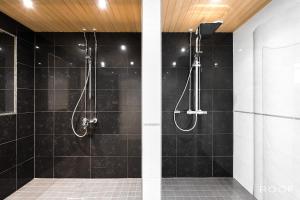 La salle de bains est pourvue d'une douche avec du carrelage noir. dans l'établissement Cozy Holiday Home with Outside Jacuzzi, à Espoo