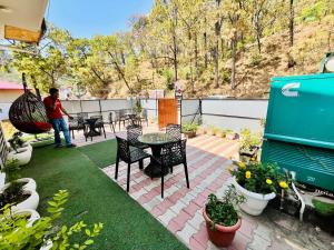 a man standing on a patio with a table and chairs at Weekend Vibes in Kasauli