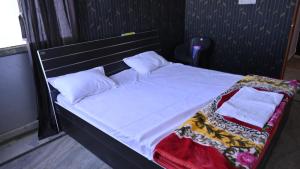 a bed with white sheets and pillows in a room at Great escape in Lucknow