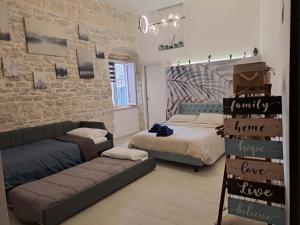 a room with two beds and a couch in it at Maison Divino in Trani