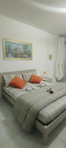 een groot bed met oranje kussens in een slaapkamer bij Aurora appartamento, intero appartamento di 105 mq in Terni
