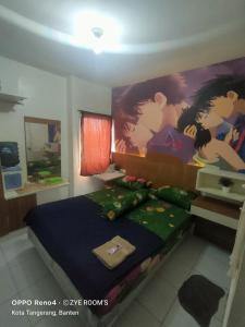 a bedroom with a bed with a painting on the wall at Zye Rooms apartemen in Teko
