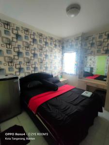 a bedroom with a bed and a wall with pictures at Zye Rooms apartemen in Teko