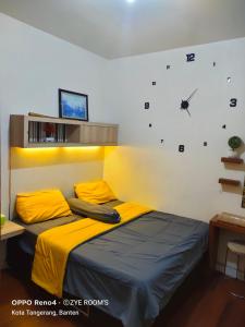 a bedroom with a bed and a clock on the wall at Zye Rooms apartemen in Teko