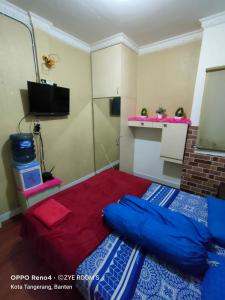 a small room with a bed and a tv at Zye Rooms apartemen in Teko