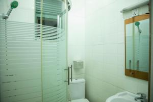 uma casa de banho com um chuveiro, um WC e um lavatório. em LEED Homes em Kigali