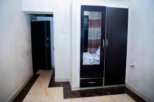 um corredor com dois armários pretos e um espelho em LEED Homes em Kigali
