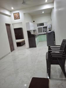 a large living room with chairs and a kitchen at 636 Kedia Kothhi in Jaipur