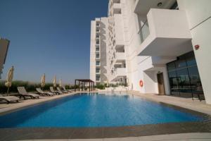 a swimming pool in front of a building at Warm and Elegant Studio in Dubai in Dubai