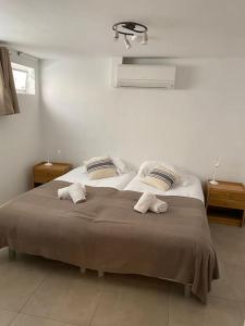 1 dormitorio con 1 cama con 2 toallas en BEAU REZ DE JARDIN- Cannes Suquet - Clim- Calme - Lumineux- 15 minutes Palais des Festival, en Cannes
