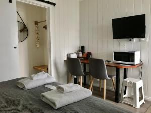 Beachend Bicheno في بيتشينو: غرفة بسرير ومكتب مع تلفزيون