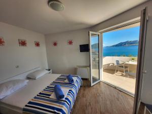 a bedroom with a bed and a view of the ocean at AtlantisPagNovalja in Zubovići