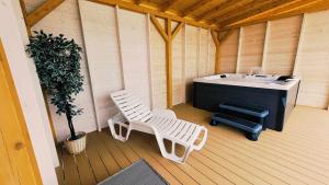 una sauna con bañera y una silla en una terraza en Mazurska Przystań, en Giżycko