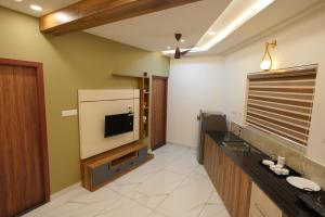 a living room with a tv and a large screen at M!steria Inn near Banasura sagar in Wayanad