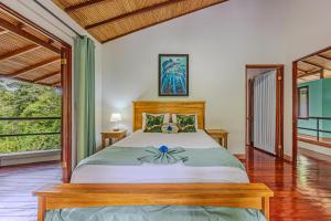 1 dormitorio con cama y ventana grande en The Jungle Inn en Dominicalito