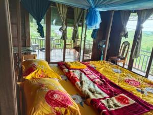 a bedroom with two beds with colorful blankets at Banlung Hill Top House &Trekking in Phumĭ Pôy