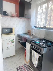 Il comprend une cuisine équipée d'une cuisinière et d'un réfrigérateur. dans l'établissement Mudzini one bedroom, à Mombasa