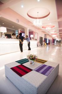 dos hombres parados en un vestíbulo con una mesa en el suelo en Boonsiri Boutique Hotel, en Sisaket
