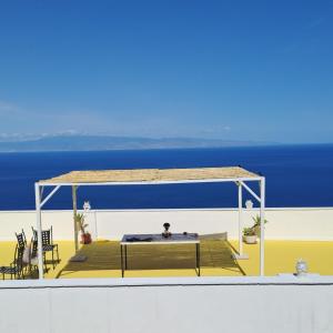 a deck with a table and chairs and the ocean at Johnny and Mary's house breathtaking view locazioneturistica in Taormina