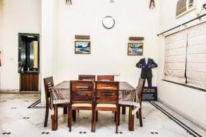 a dining room with a table and chairs and a clock at Goroomgo Ullash Residency Salt Lake City Kolkata - Luxurious Room Quality - Excellent Customer Service in kolkata