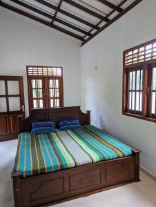 a bedroom with a bed in a room with windows at Uma Guest House in Kahawa