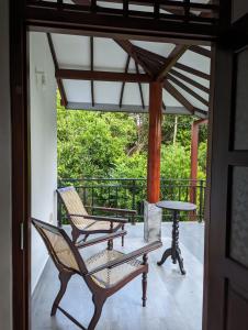 a patio with two chairs and a table on a porch at Uma Guest House in Kahawa