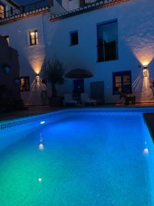 een zwembad voor een huis 's nachts bij Casa Morayma, Lecrin, Granada (Adult Only Small Guesthouse) in Acequias