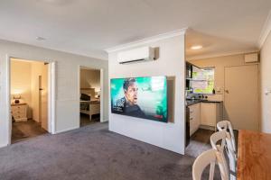 549 Luxury Apartments في خليج هيرفي: غرفة معيشة مع تلفزيون بشاشة مسطحة على جدار