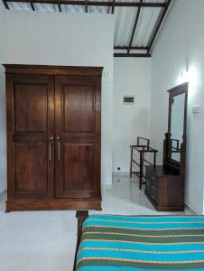 a bedroom with a wooden cabinet and a mirror at Uma Guest House in Kahawa