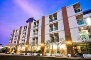 a large white building with trees in front of it at Boonsiri Boutique Hotel in Si Sa Ket