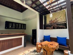 a living room with a wooden table and blue pillows at Bumbung Sari Villa in Ubud