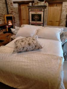 1 cama blanca grande con almohada en Maison en Pierre en Fiastra