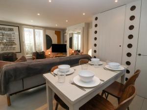 uma sala de estar com uma mesa e um sofá em Mariners Cottage em Aldeburgh