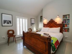 um quarto com uma cama grande e uma estante de livros em Mariners Cottage em Aldeburgh