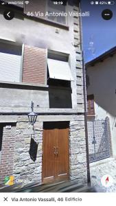 un edificio de piedra con una puerta de madera. en Il Castello en CastellʼArquato