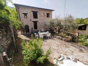 菲亚斯特拉Maison en Pierre的一间房子，前面有一张桌子和几把椅子