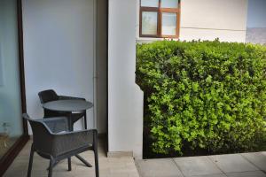 a table and chairs next to a green hedge at HOM I Precioso Loft Jardin para 2PAX en mejor Ubicación 991 in Valparaíso