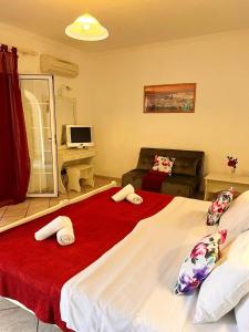 a bedroom with a large bed with a red blanket at Apart Hotel Blumarin in Agios Gordios