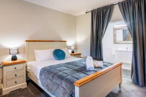 a bedroom with a bed with blue pillows on it at Cypress BnB in Hervey Bay