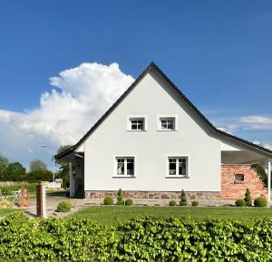 a white house with a black roof at „Holzwurm-Paradies“ in Ivenack