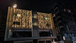 瓦皮Hotel JDS的夜晚亮着灯的建筑物