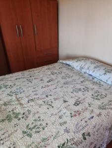 een bed met een dekbed in een slaapkamer bij Apartamento Estudio in Valparaíso