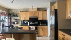 a kitchen with wooden cabinets and a black counter top at Private Room Male Only North Side Edmonton 165 Ave 56 Street Walking Distance to Strip Mall in Edmonton