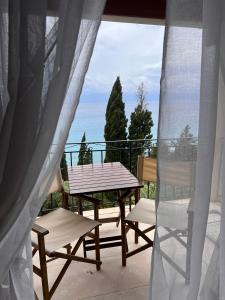 un patio con tavolo e sedie sul balcone. di Stefanos Apartments by SV Alians ad Agios Gordios