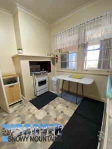 a small kitchen with a stove and a table at Inglewood Cottage in Adaminaby