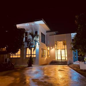 una casa blanca por la noche con entrada en Romlaphass Boutique hotel, en Kalasin