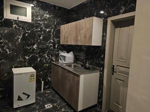 a kitchen with a sink and a black wall at استديو انيق وراقي in Riyadh